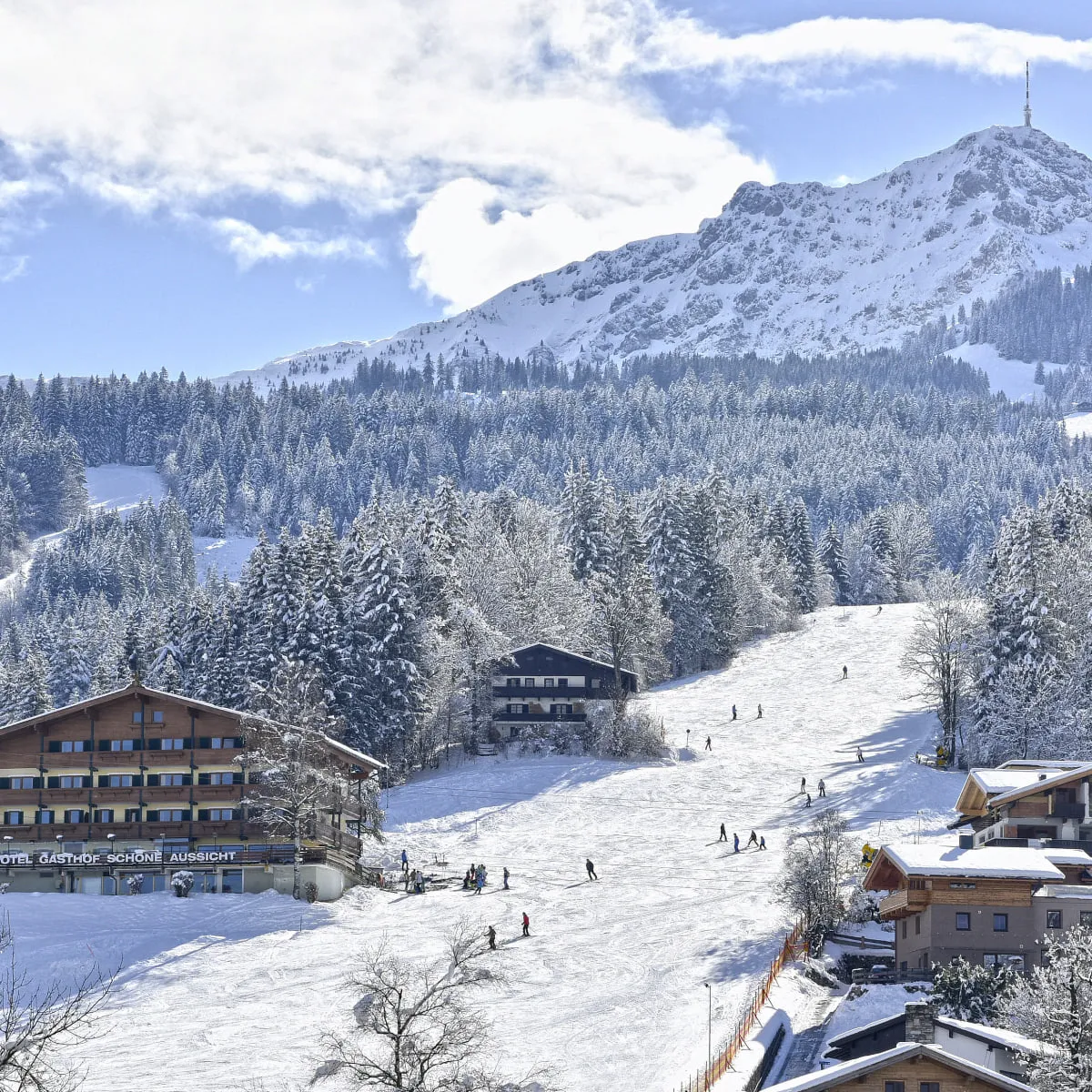 Schneebedeckte Berge und Ski-Aktivitäten im Hintergrund