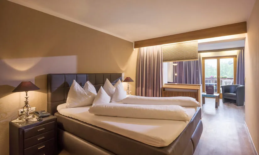Modernes Hotelzimmer mit Doppelbett und Balkonzugang
