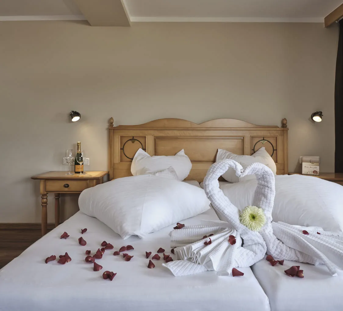 Hochzeitszimmer mit Rosenblättern und dekorativen Handtüchern