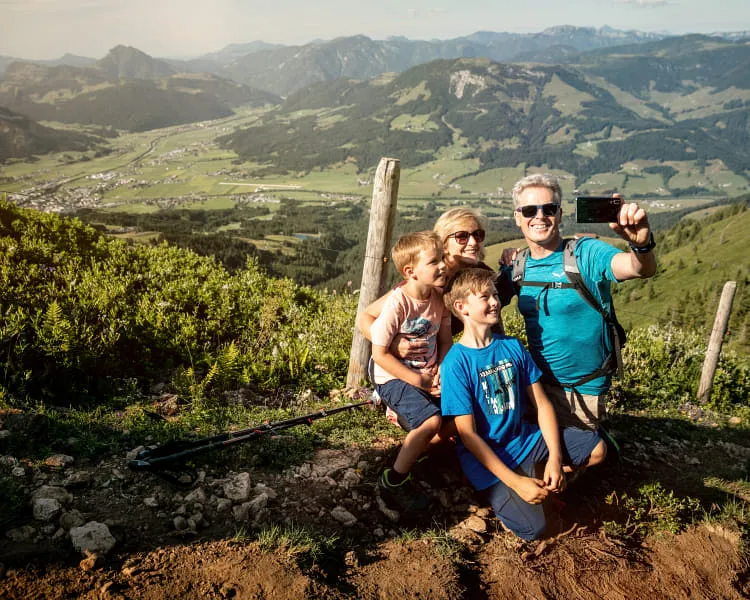 Familie macht ein Selfie beim Wandern in St. Johann in Tirol