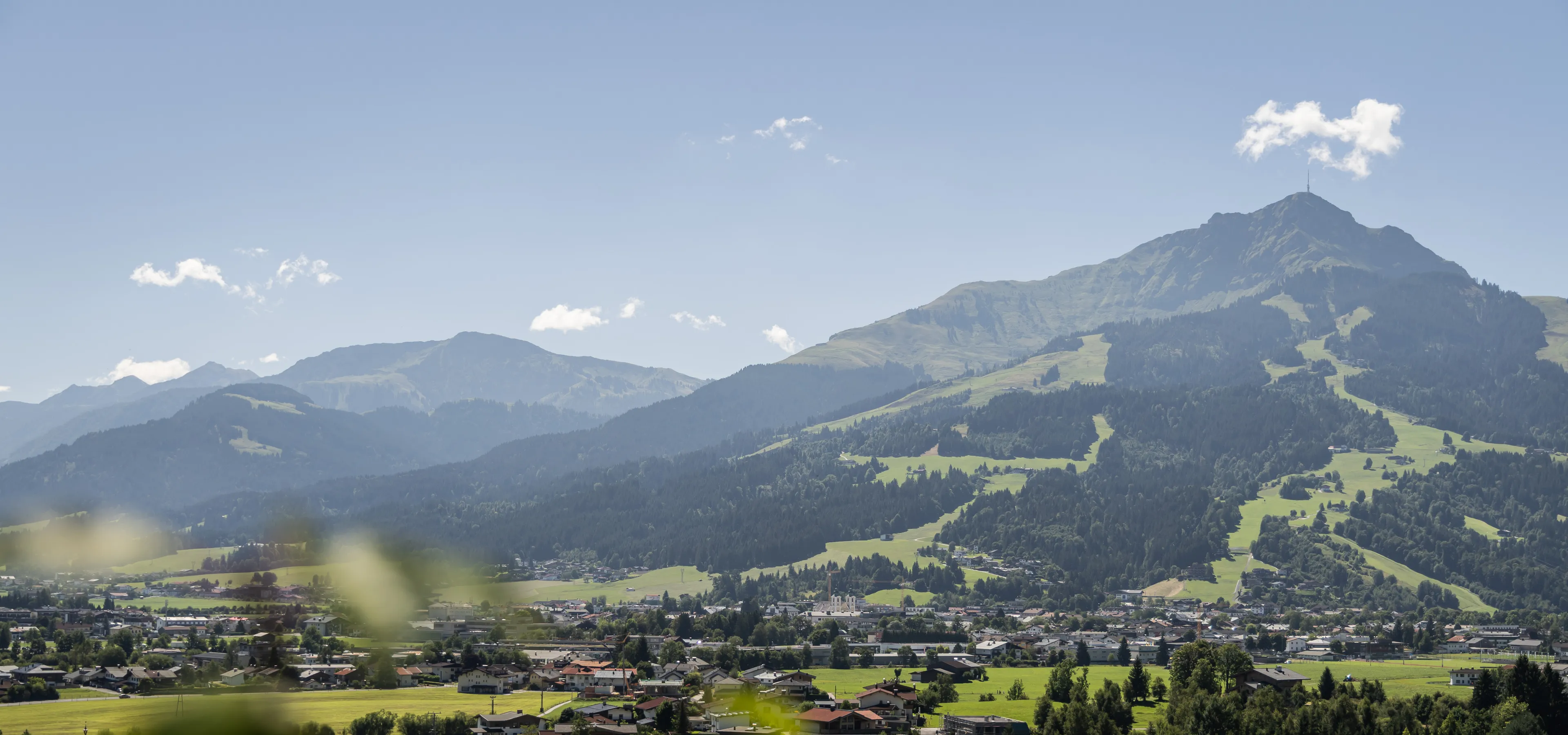 Blick auf St. Johann mit Bergen und Wolken