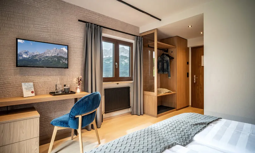 Helles Hotelzimmer mit Fernsehen und gemütlichem Sessel