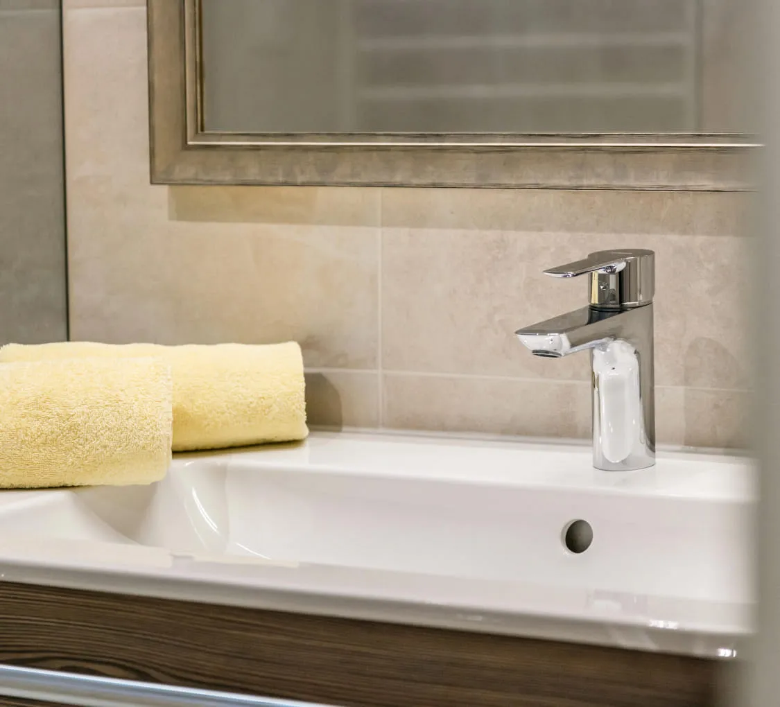 Badezimmer mit Waschbecken und gelbem Handtuch