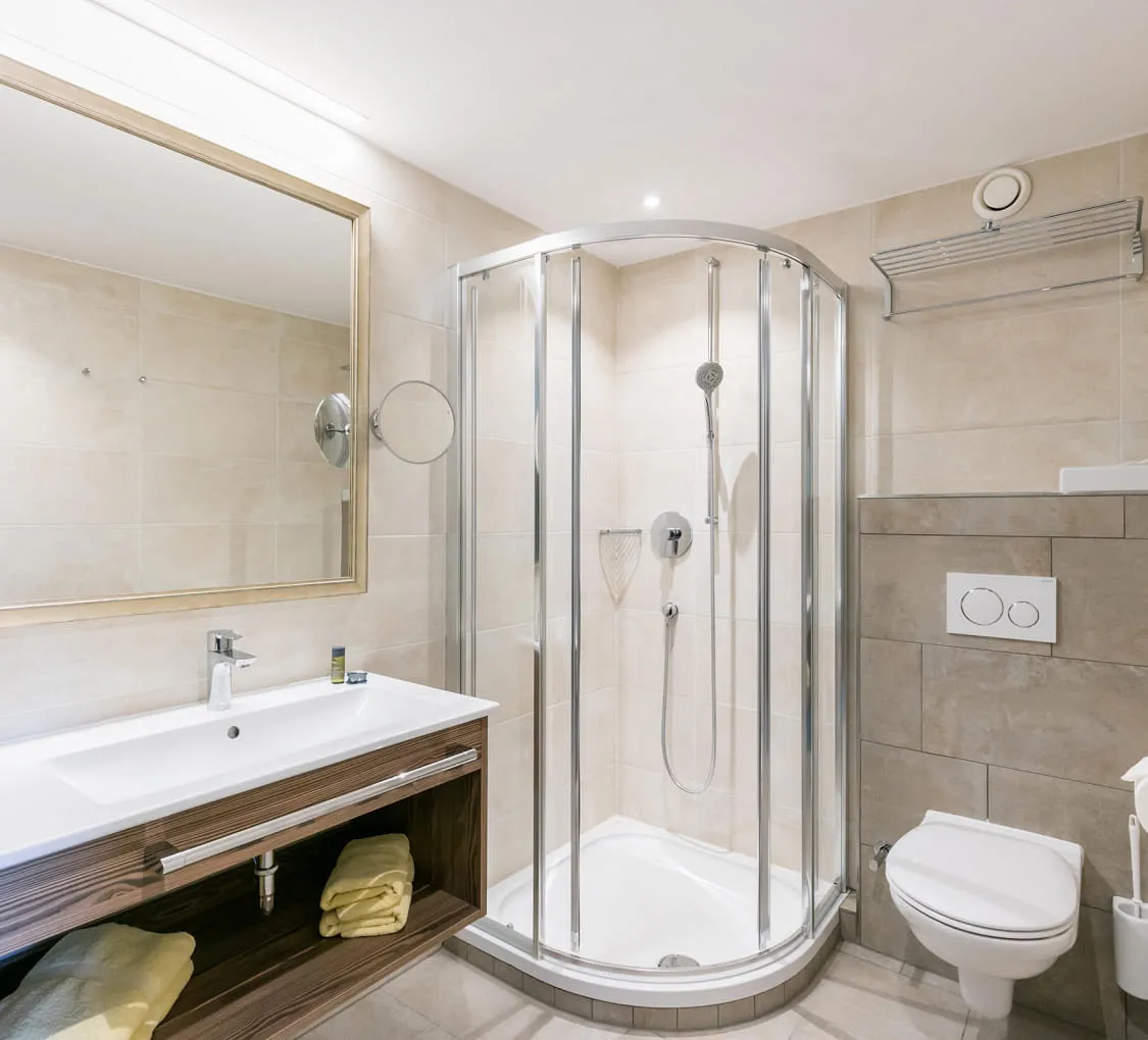 Modernes Badezimmer mit Dusche, Toilette und Spiegel