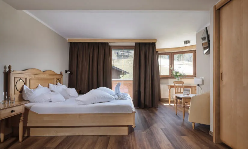 Helles Zimmer mit Holzfußboden und großen Fenstern.