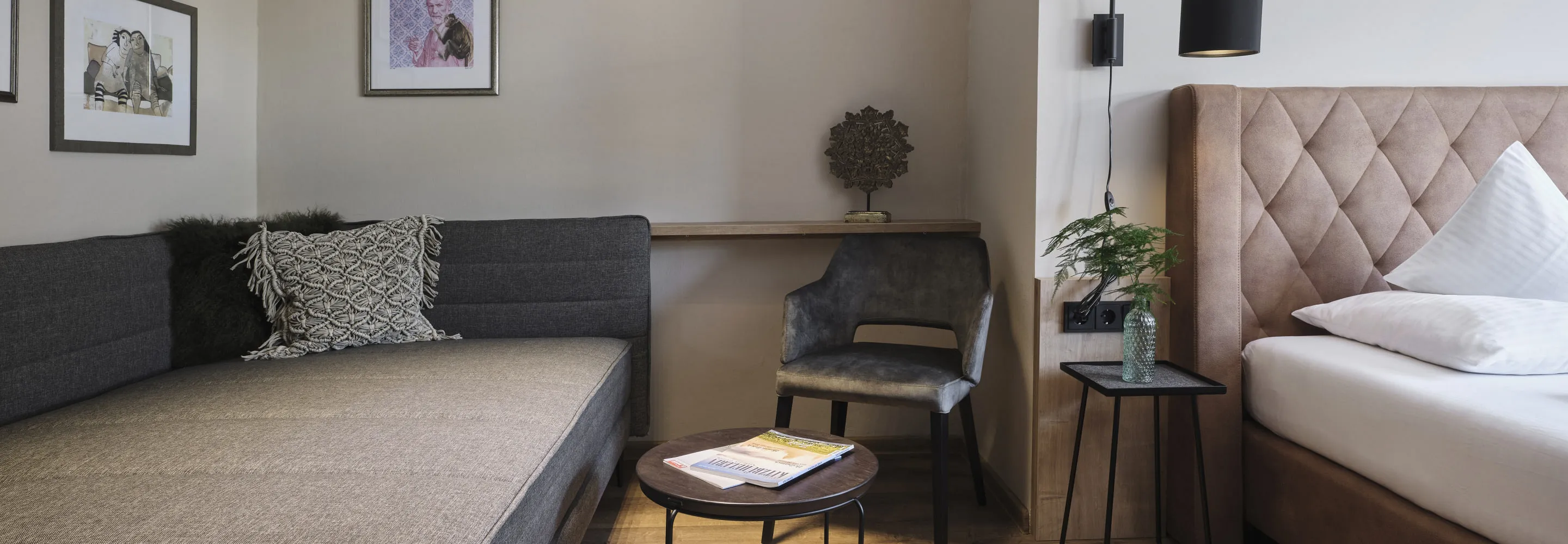 Modernes Zimmer mit Bett, Couch und dekorativen Elementen