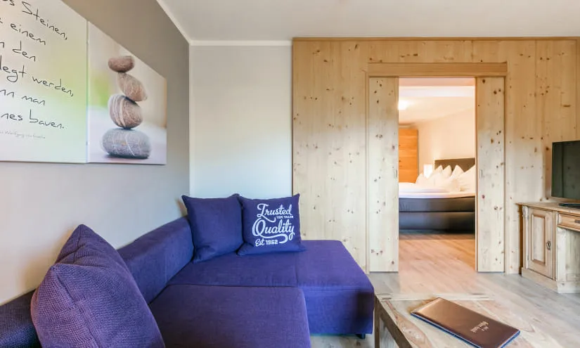 Helles Zimmer mit Sofa und Blick auf ein Holzpaneel