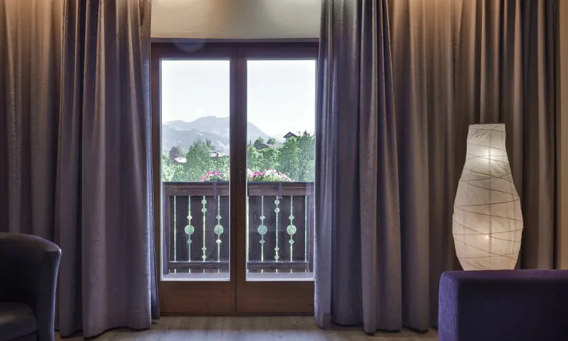 Blick aus einem Zimmer mit Vorhängen und einer Lampe