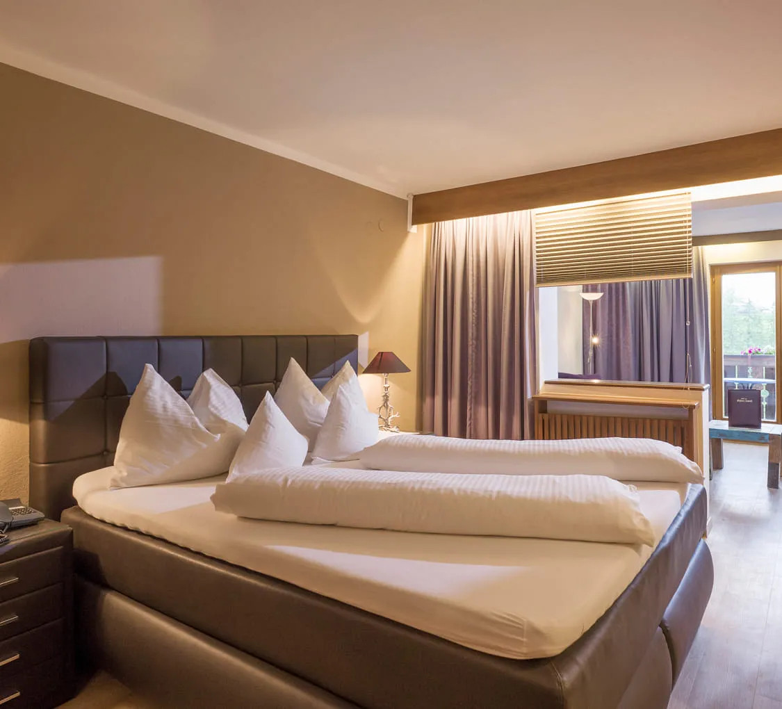 Helles Zimmer mit Doppelbett und Balkonblick auf die Natur