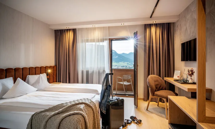 Helles Hotelzimmer mit Bergblick und modernem Design.