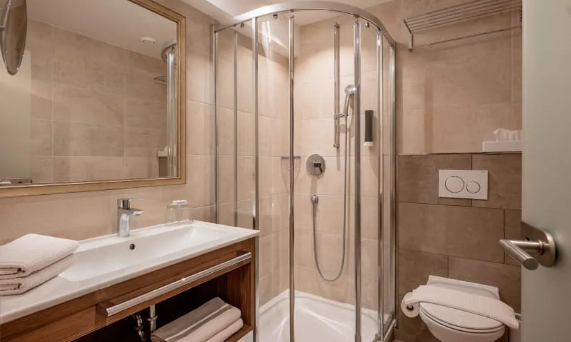 Badezimmer mit Dusche, Spiegel und Waschbecken